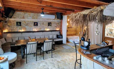 a dining room with a wooden table and chairs at Hedonizam Lux in Podgorica