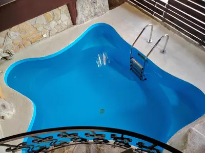 a swimming pool with blue water in a backyard at Hedonizam Lux in Podgorica
