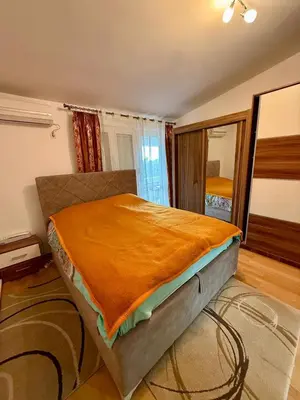 a bedroom with a bed with an orange blanket on it at Sutomore 3-bedroom apartment in Sutomore