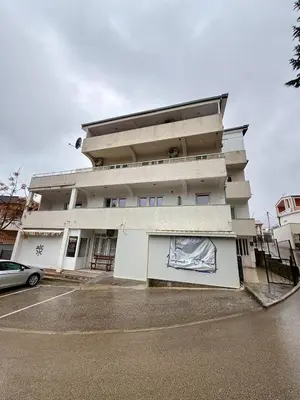 a white building with a car parked in front of it at Sutomore 3-bedroom apartment in Sutomore
