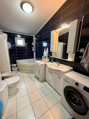 a bathroom with a toilet sink and a washing machine at Sutomore 3-bedroom apartment in Sutomore