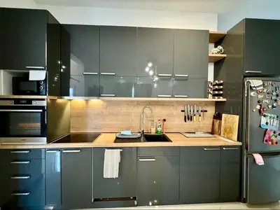 a kitchen with gray cabinets and a sink and a refrigerator at Bar Lux Two-Bedroom apartment in Bar