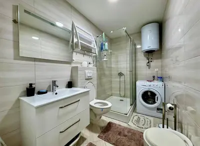 a bathroom with a toilet sink and a washing machine at Bar Lux Two-Bedroom apartment in Bar