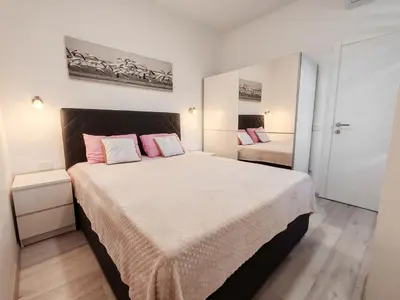 a bedroom with a large bed with pink pillows at Serenity Apartment in Becici
