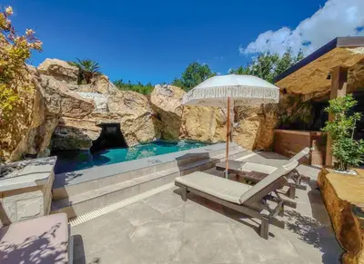 a patio with an umbrella and a chair and a pool at Serenity Apartment in Becici