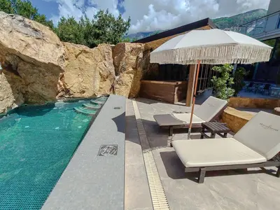 a swimming pool with two lounge chairs and an umbrella at Serenity Apartment in Becici