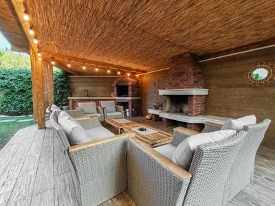 an outdoor patio with wicker chairs and a fireplace at Serenity Apartment in Becici