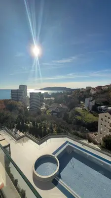 a view of a swimming pool with the sun in the sky at Status Complex in Becici