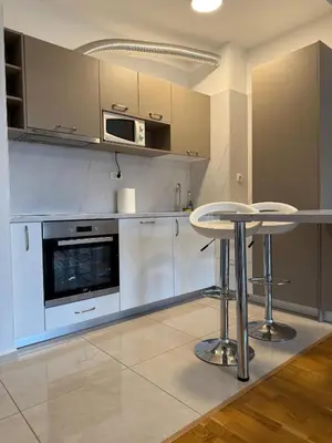 a kitchen with two stools and a table in it at Status Complex in Becici