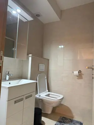 a bathroom with a white toilet and a sink at Status Complex in Becici
