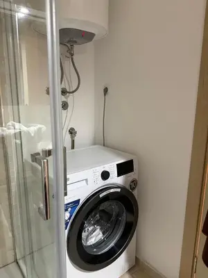 a washing machine in a bathroom with a shower at Status Complex in Becici