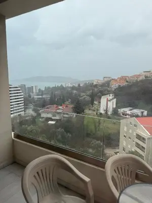 a window with two chairs and a view of a city at Status Complex in Becici