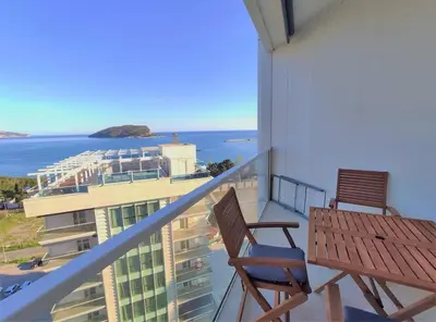 a balcony with two chairs and a view of the ocean at Vista Deluxe apartment - Tre Canne Budva in Budva