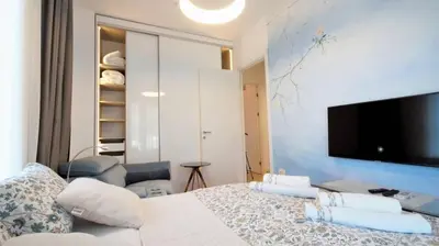 a bedroom with a bed and a tv on a wall at Vista Deluxe apartment - Tre Canne Budva in Budva