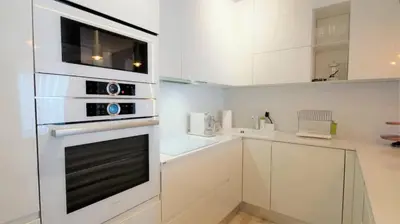 a kitchen with white cabinets and a microwave oven at Vista Deluxe apartment - Tre Canne Budva in Budva