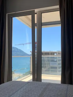 a bedroom with a window with a view of the ocean at Vista Deluxe apartment - Tre Canne Budva in Budva