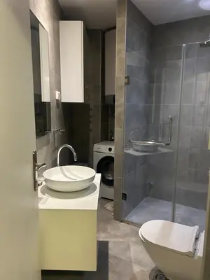 a bathroom with two sinks and a toilet and a shower at Apartmani Masa in Podgorica
