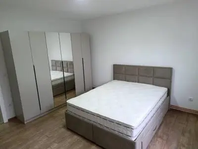 a white room with a bed and a mirror at Apartmani Masa in Podgorica