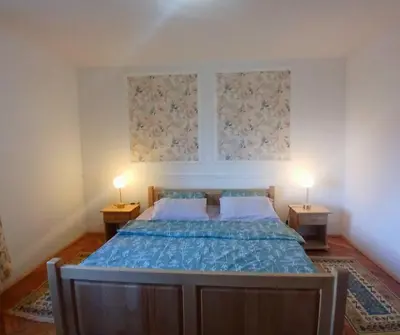 a bedroom with a bed with two lamps on two tables at Kapa's House in Cetinje