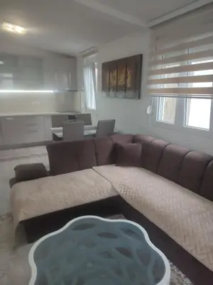 a living room with a brown couch and a table at Bar ,2 sobni stan ,Namaste ! in Bar