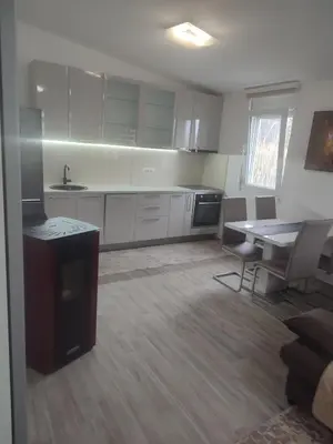 a kitchen with white cabinets and a table and chairs at Bar ,2 sobni stan ,Namaste ! in Bar