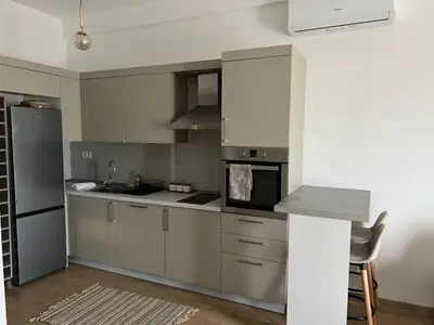 a kitchen with stainless steel appliances and a table at Studio UNA - PMTR Building, BAR in Bar