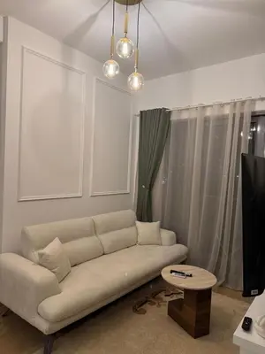 a living room with a white couch and a table at Studio UNA - PMTR Building, BAR in Bar
