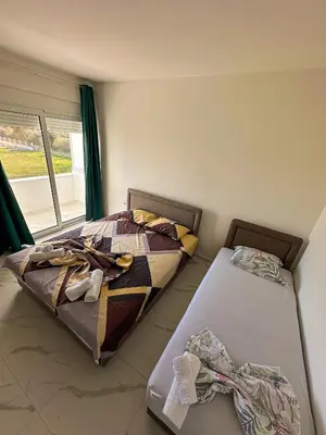 two beds sitting next to each other in a bedroom at Gzim Peja in Ulcinj