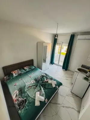 a bedroom with a bed with a green comforter at Gzim Peja in Ulcinj