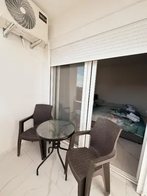 a balcony with a table and chairs and a bedroom at Gzim Peja in Ulcinj