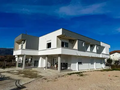 a white building with a black roof at Gzim Peja in Ulcinj