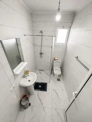 a white bathroom with a sink and a toilet at Gzim Peja in Ulcinj