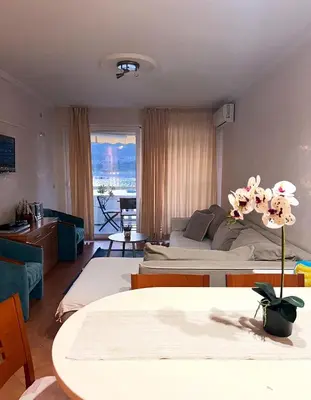 a bedroom with two beds and a living room at Seaview Rafailovici in Rafailovici