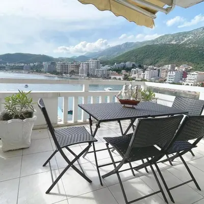a table and chairs on a balcony with a view at Seaview Rafailovici in Rafailovici