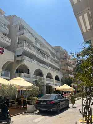 a car parked in front of a large building at Seaview Rafailovici in Rafailovici