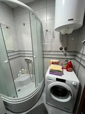 a bathroom with a washing machine and a shower at Apartment Mirabella in Podgorica