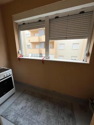 a kitchen with a window with a view of a building at Apartment Mirabella in Podgorica