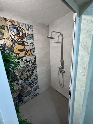 a bathroom with a shower with a mosaic wall at Spa apartment Residence, with 2 pools and jacuzzi in Golubovci