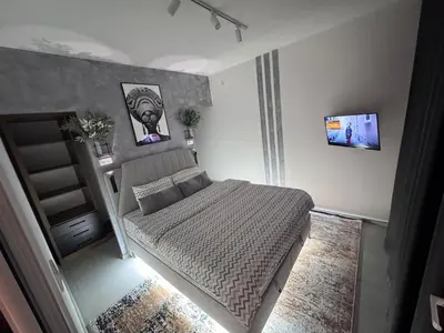 a small bedroom with a bed and a tv at Spa apartment Residence, with 2 pools and jacuzzi in Golubovci
