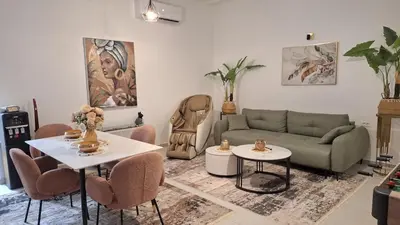 a living room with a couch and a table and chairs at Spa apartment Residence, with 2 pools and jacuzzi in Golubovci
