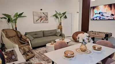 a living room with a couch and a table and chairs at Spa apartment Residence, with 2 pools and jacuzzi in Golubovci
