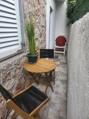 a wooden table and chairs on a patio at Morska Oaza Sutomore in Sutomore
