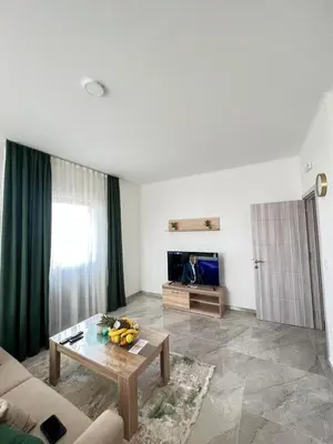 a living room with a table and a television at Mir i More in Dobra Voda