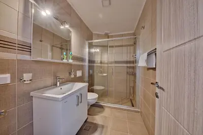 a bathroom with a toilet and a sink and a shower at Mir i More in Dobra Voda
