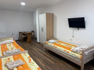 two beds in a room with a tv on the wall at Njaro del Mar Zukovica 2 in Žukovica