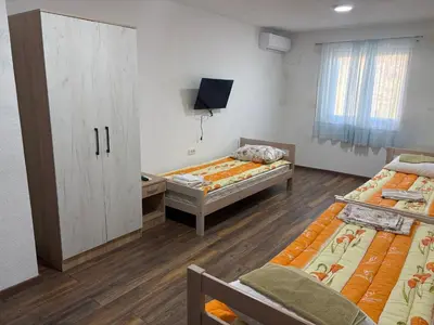 a room with two beds and a tv in it at Njaro del Mar Zukovica 2 in Žukovica