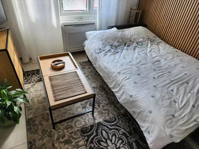 a bed in a room with a table next to it at Broj 4 in Podgorica