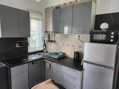 a small kitchen with a refrigerator and a microwave at Broj 4 in Podgorica