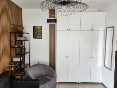 a living room with a chair and a chandelier at Broj 4 in Podgorica