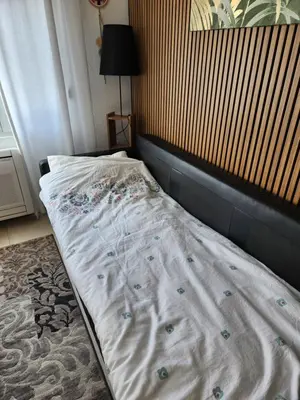 an unmade bed in a room with at Broj 4 in Podgorica